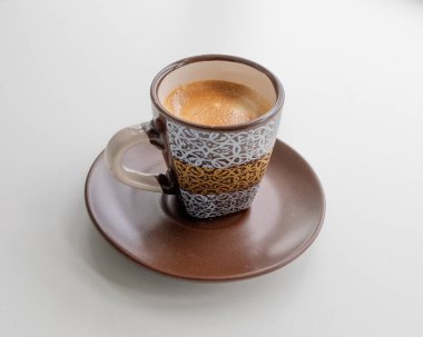 Kahverengi bir bardakta espresso ve sabah beyaz bir parmak izi.