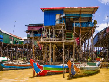 Traditional Kampong Phluk floating village with multicolored boats and stilt houses, Tonle Sap lake, Siem Reap Province, Cambodia clipart