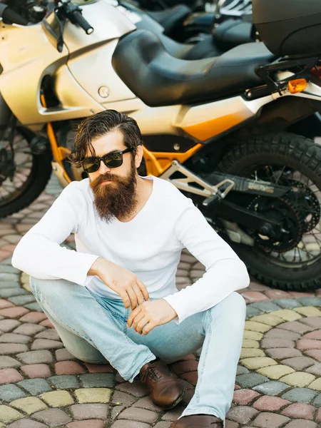 Hombre atractivo se sienta cerca de la motocicleta — Foto de Stock