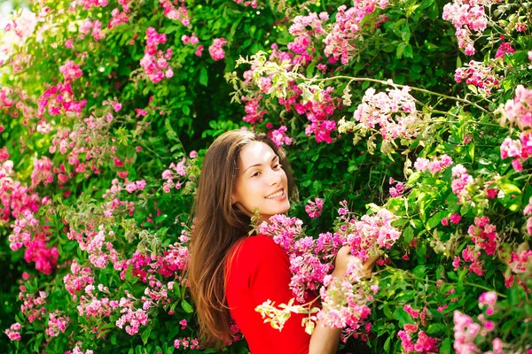 Chica bonita entre flores florecientes — Foto de Stock