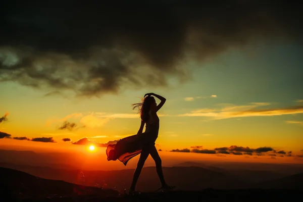 Mujer al atardecer o al amanecer en las montañas — Foto de Stock