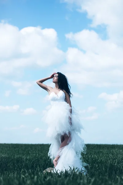 Mooie bruiloft meisje op het groene gras en hemel — Stockfoto