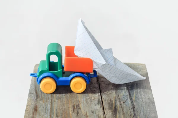 Toy truck unloads paper boat — Stock Photo, Image