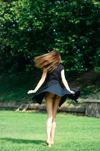 Atrakcyjna, młoda dziewczyna w granatowa sukienka na trawniku — Zdjęcie stockowe