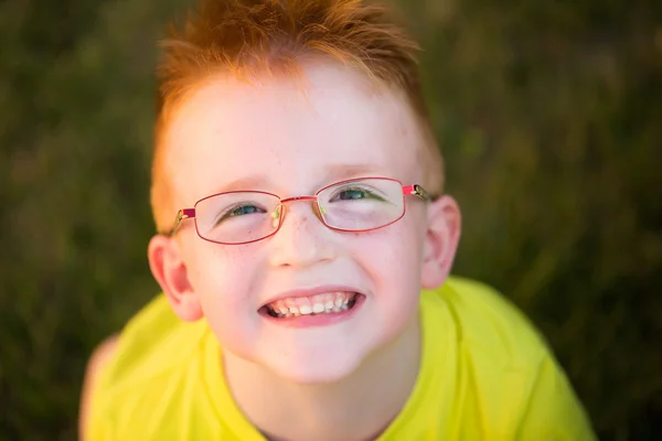 Niño feliz con el pelo rojo en gafas — Foto de Stock