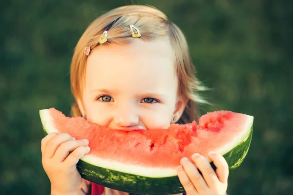 Flicka äter röd vattenmelon utomhus — Stockfoto