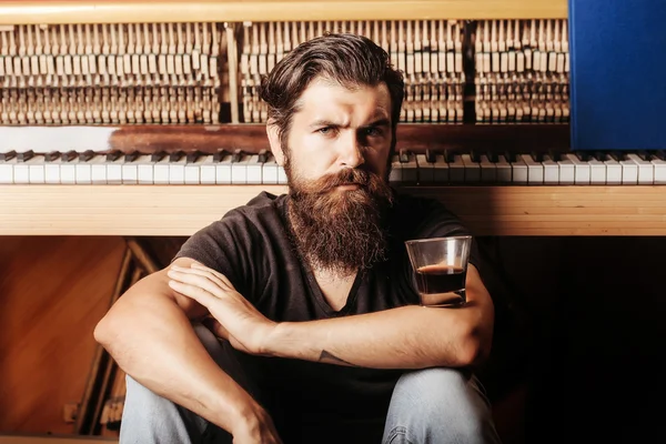 Bearded man with glass near wood piano — Stock Photo, Image