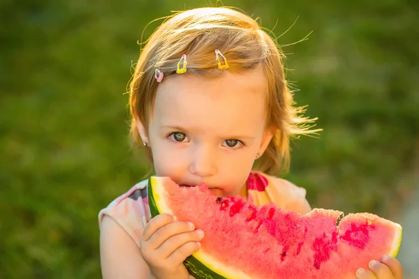 Flicka äter röd vattenmelon utomhus — Stockfoto