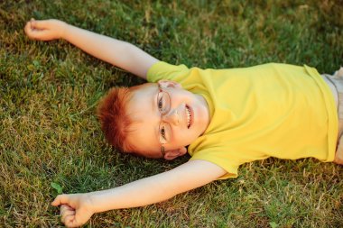 Çimenlerin üzerinde bardaklarda Kızıl saçlı erkek mutlu bebek