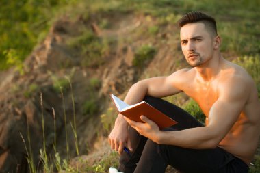 Kitap açık olan dalgın kaslı adam