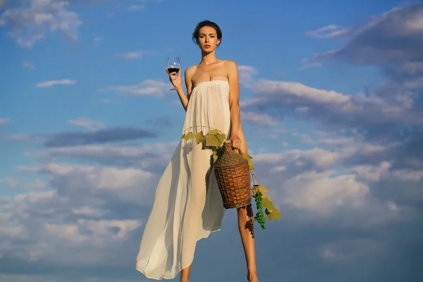 Ładna dziewczyna z butelką wina nad niebem — Zdjęcie stockowe