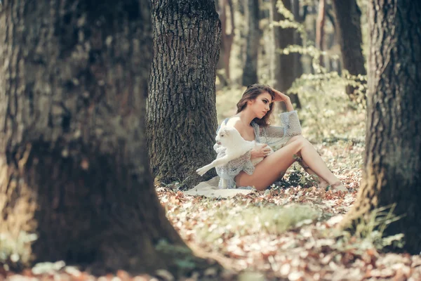 Jonge vrouw met geit in bos — Stockfoto