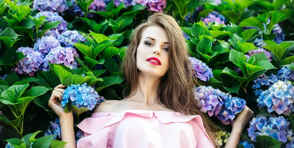 Menina bonita em flores de hortênsia — Fotografia de Stock