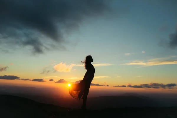 Kvinnan vid solnedgång eller soluppgång i bergen — Stockfoto