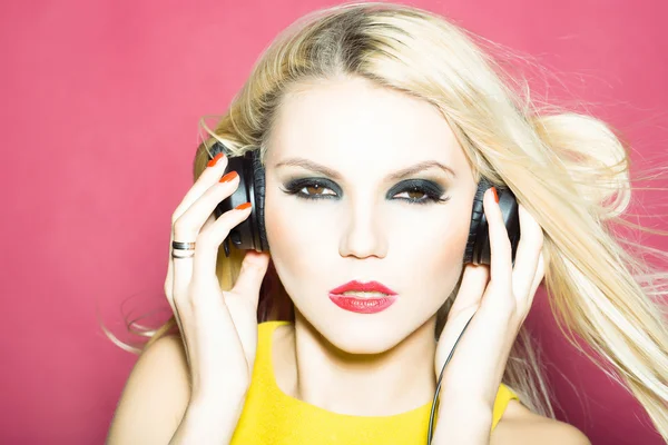 Vacker blond GD flicka i headsetet på pink — Stockfoto