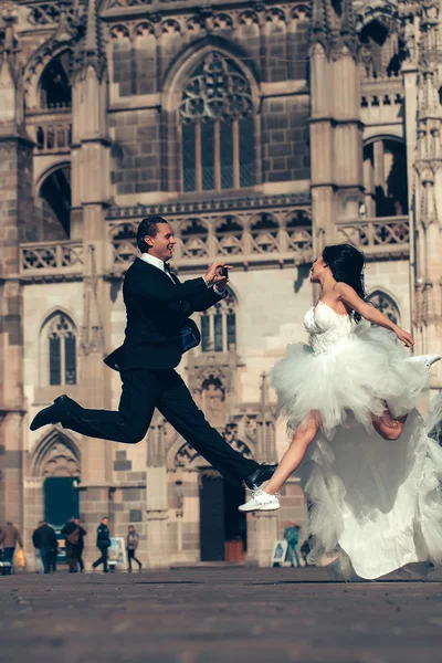 Wedding happy couple jumping near castle — Stock Photo, Image