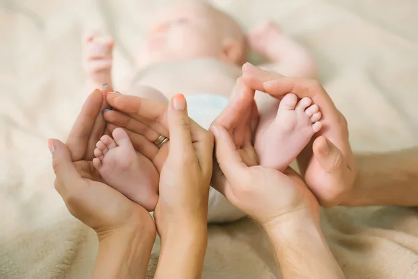 Pieds nouveau-nés dans les mains des parents — Photo
