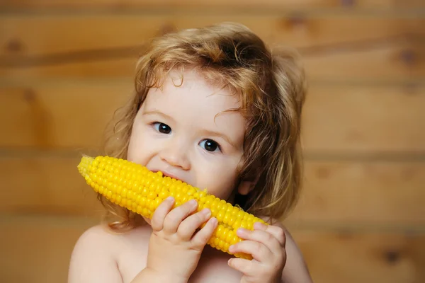 Engraçado menino pequeno criança comendo milho amarelo — Fotografia de Stock