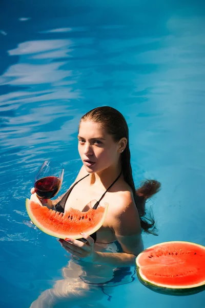 Donna con anguria e vino in piscina — Foto Stock