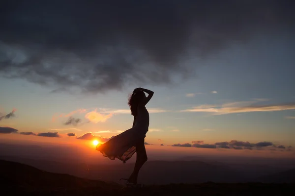 Mujer al atardecer o al amanecer en las montañas — Foto de Stock