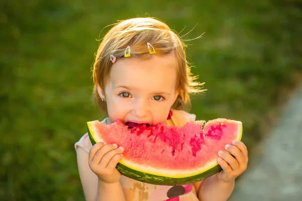 Flicka äter röd vattenmelon utomhus — Stockfoto