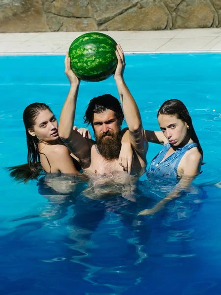 Femmes et homme avec pastèque dans la piscine — Photo