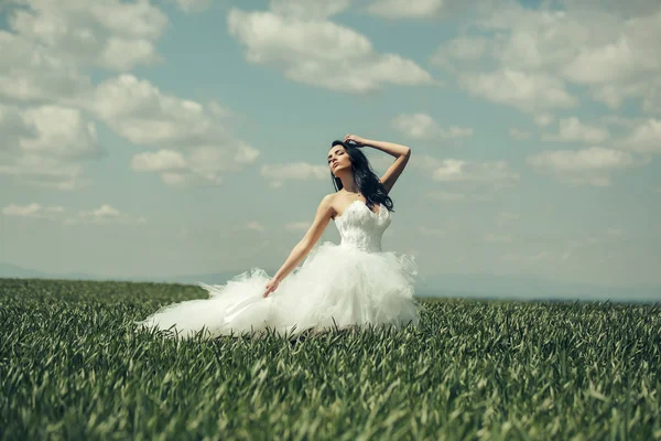 Bonita chica de la boda en hierba verde y el cielo —  Fotos de Stock