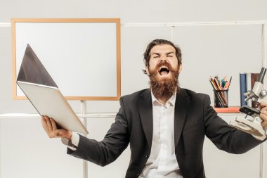Dizüstü bilgisayarı olan kızgın iş adamı