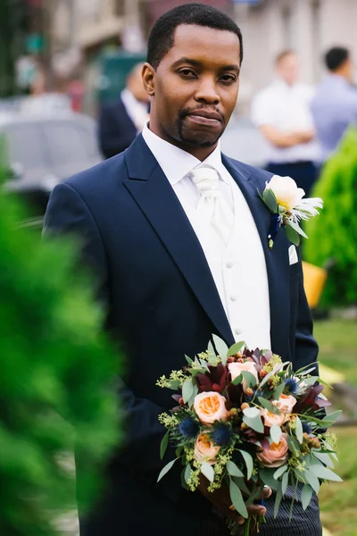Handsome groom with wedding bouquet