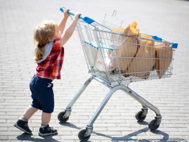 Sevimli çocuk alışveriş arabası itme
