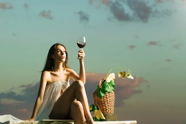 Hübsche Frau mit Wein über dem Himmel — Stockfoto