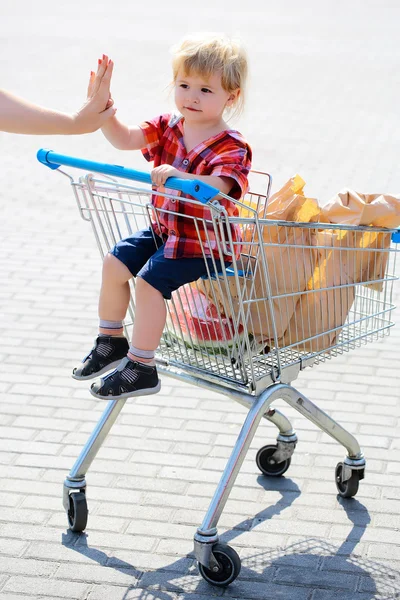 쇼핑 트롤리에서 귀여운 소년 — 스톡 사진