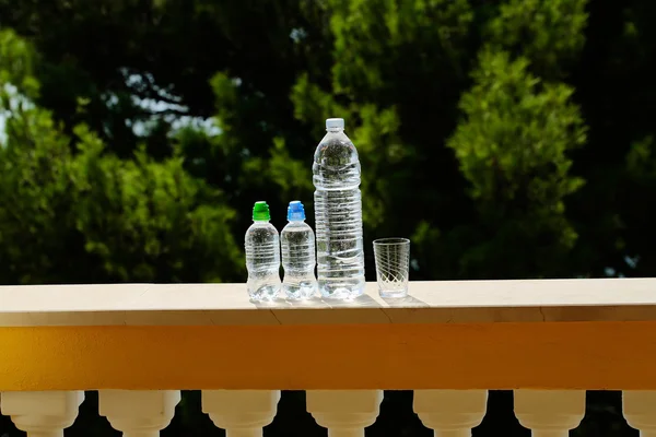 Three plastic bottles and glass — Stock Photo, Image
