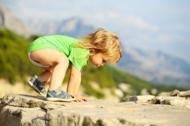 Erkek bebek kayaların üzerinde çalış