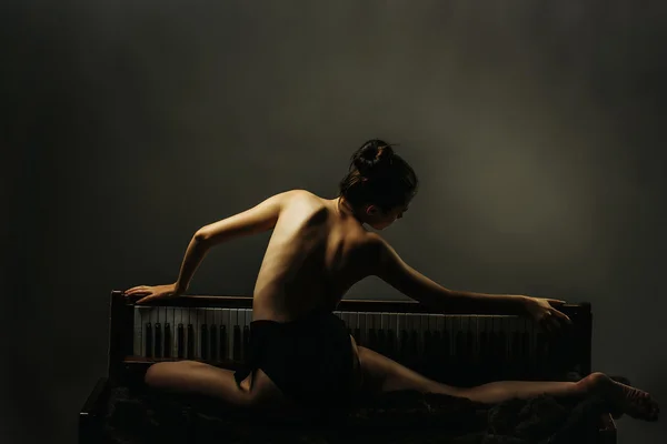 Ballerina mooi meisje op retro piano — Stockfoto