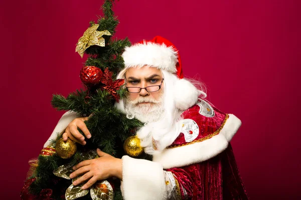 Санта-Клаус обнимает елку — стоковое фото