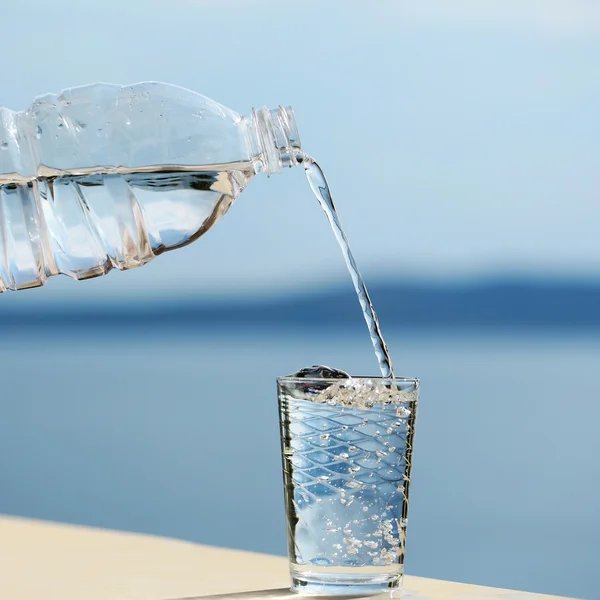 Acqua versata nel bicchiere dalla bottiglia — Foto Stock