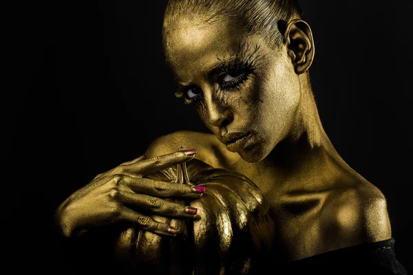Золотая женщина с тыквой на Хэллоуин — стоковое фото