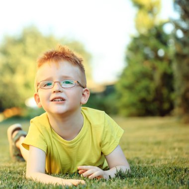 Çimenlerin üzerinde bardaklarda Kızıl saçlı erkek mutlu bebek