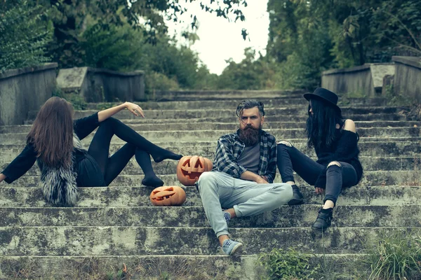 Halloween man en meisjes met pompoen — Stockfoto