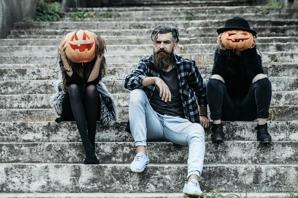 Halloween man en meisjes met pompoen — Stockfoto