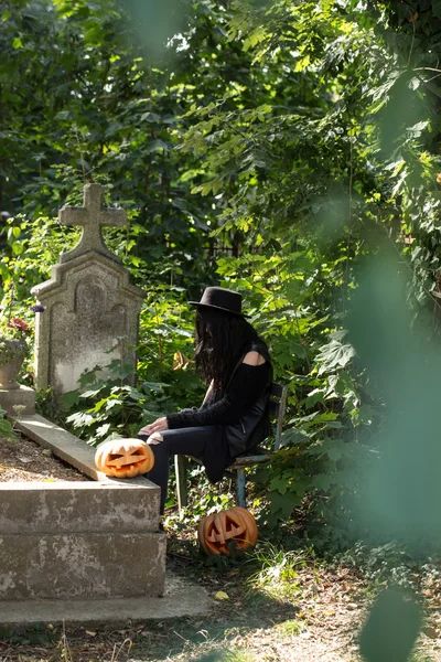 Хэллоуин женщина с тыквой на могиле — стоковое фото