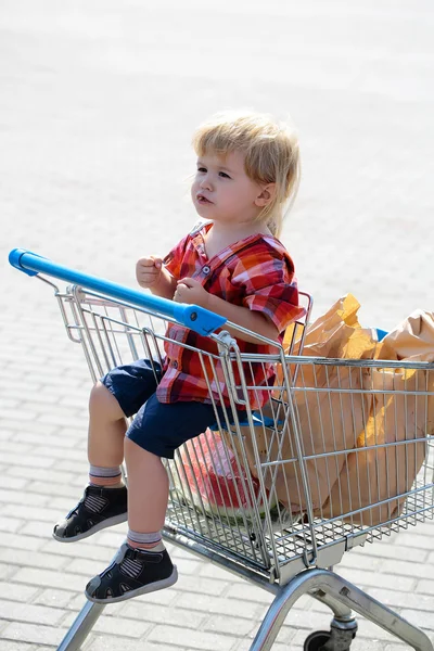 Carino ragazzo nel carrello della spesa — Foto Stock