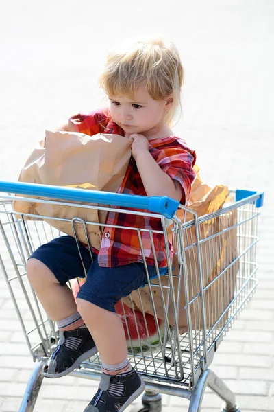 쇼핑 트롤리에서 귀여운 소년 — 스톡 사진