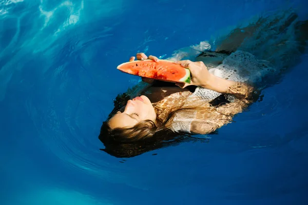 Mujer con sandía en piscina —  Fotos de Stock