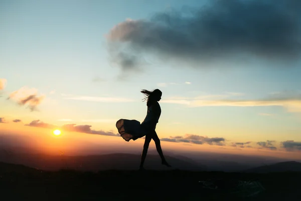 Mujer al atardecer o al amanecer en las montañas — Foto de Stock