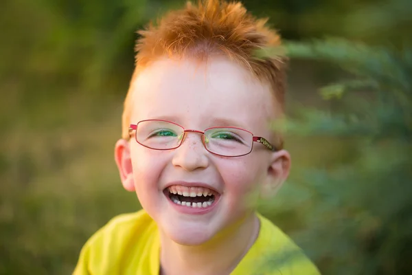 Menino feliz com cabelo vermelho em óculos — Fotografia de Stock