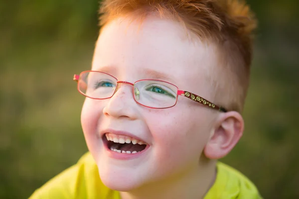 Menino feliz com cabelo vermelho em óculos — Fotografia de Stock