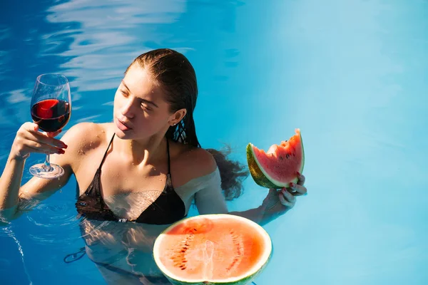 Mujer con sandía y vino en la piscina — Foto de Stock