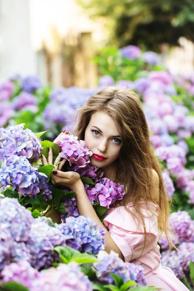 Bonita chica en hortensias flores — Foto de Stock